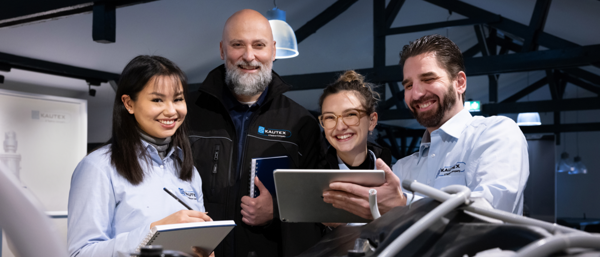 Four people smiling and holding technical equipment